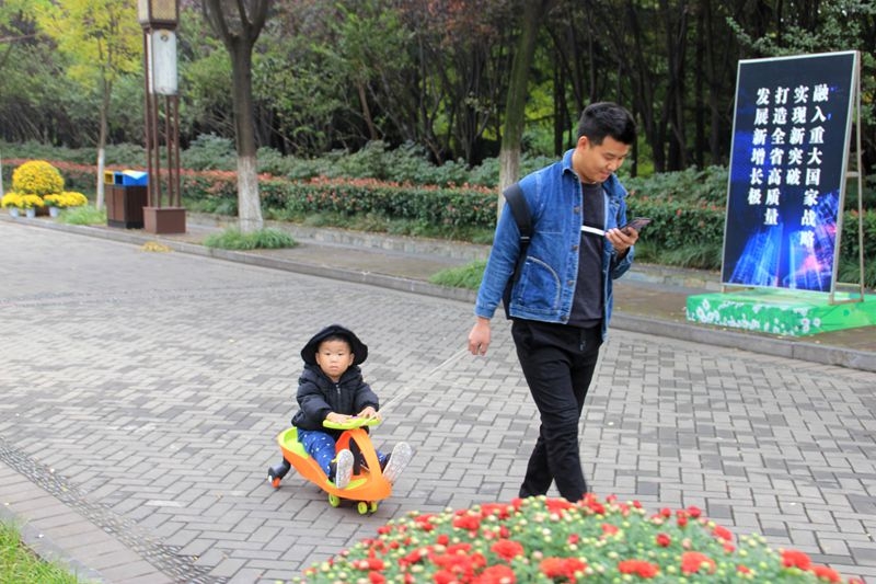 抓拍：赏花带娃看手机，休闲逛园都不误.jpg